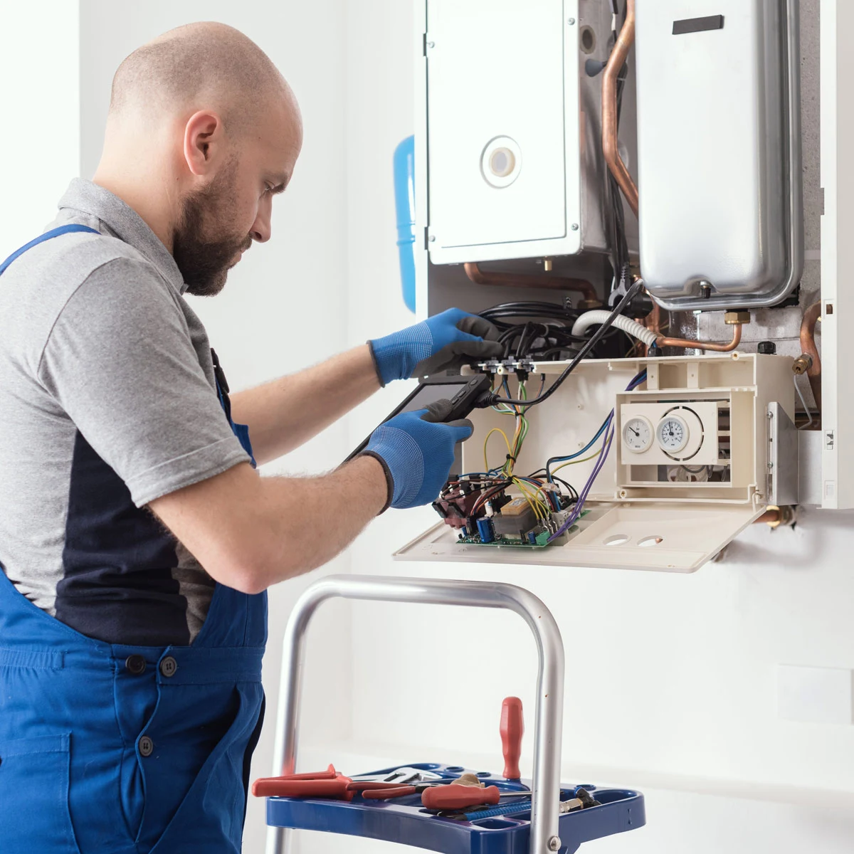 Plumber doing service fixing a boiler