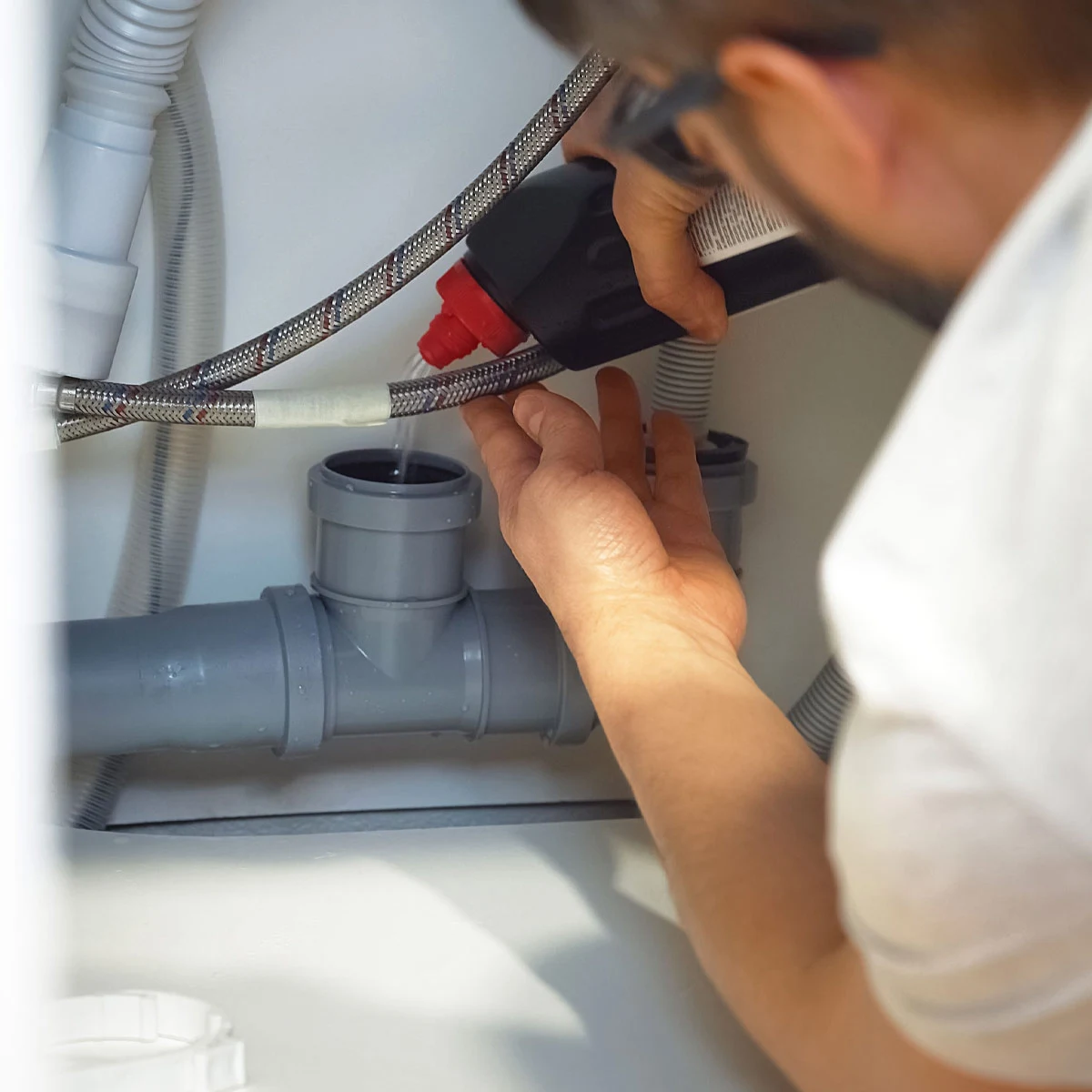 Plumber using solution on drain